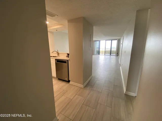 a view of a kitchen with wooden floor and stainless steel appliances