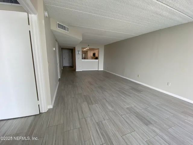 a view of a room with wooden floor and a window