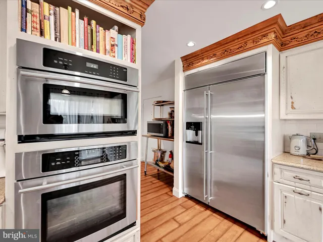 a large white kitchen with a large window and counter space