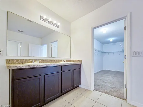 a bathroom with a granite countertop sink a large mirror and a shower