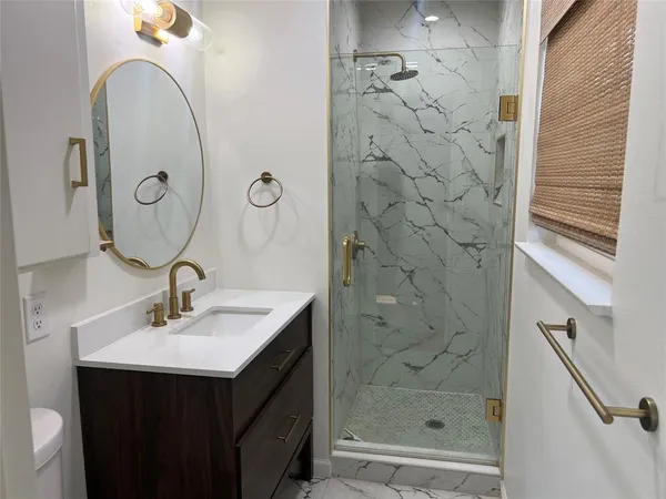 a bathroom with a sink a mirror and shower