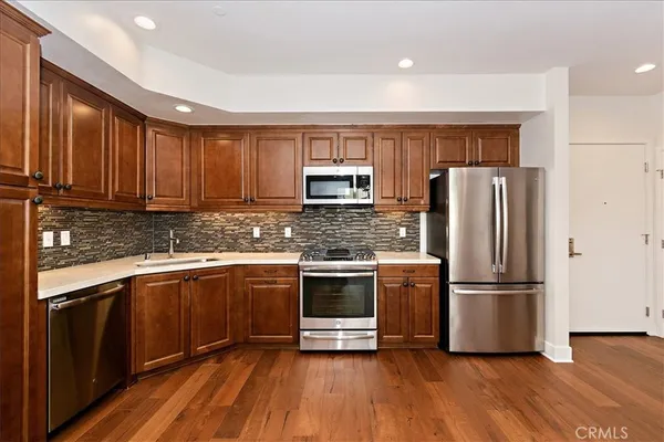 a kitchen with granite countertop stainless steel appliances and wooden cabinets