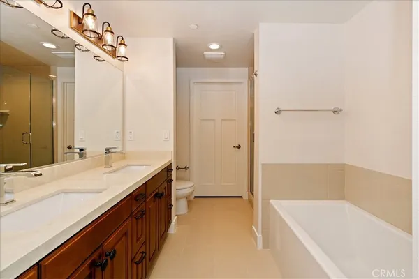 a bathroom with a tub sink and mirror