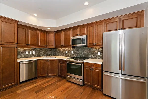a kitchen with granite countertop stainless steel appliances and wooden cabinets
