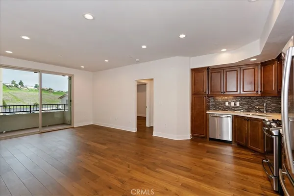 a view of kitchen with stainless steel appliances granite countertop a stove and a refrigerator