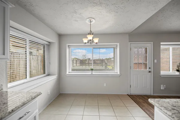 an empty room that has a window and chandelier