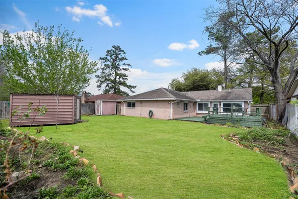a view of a house with a big yard potted plants and large tree