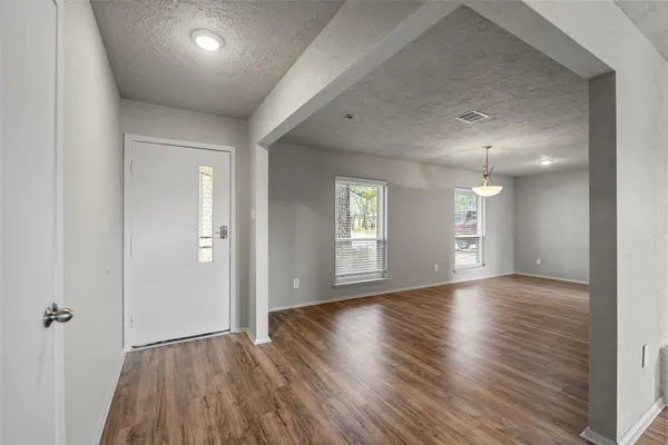 an empty room with window and wooden floor