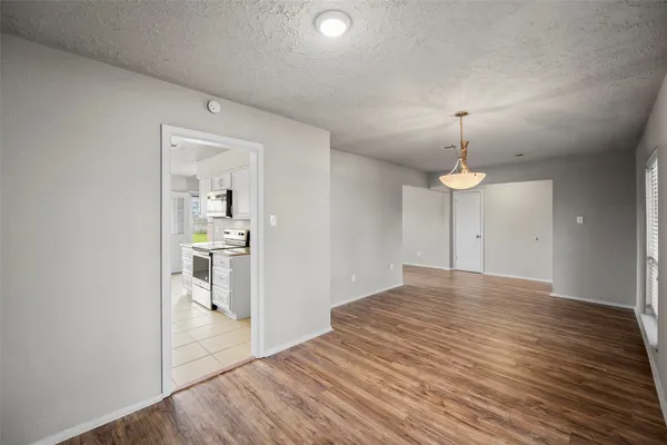 a view of empty room with wooden floor
