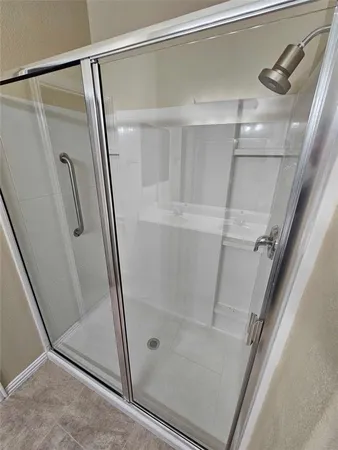 a bathroom with a glass door shower and toilet