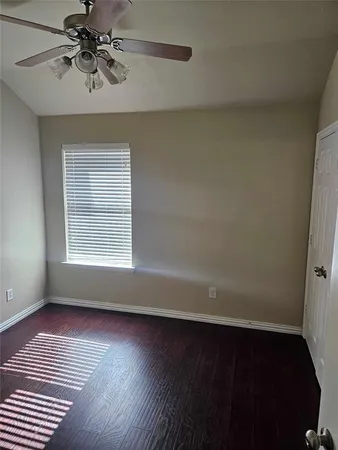 a view of room with hardwood floor and a ceiling fan