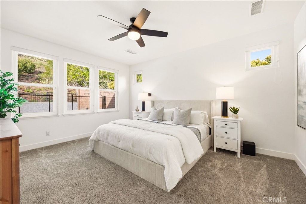 14431 Shawnee Street Moorpark, CA 93021 - Photo 19 of 72 a spacious bedroom with a bed a window and a chandelier