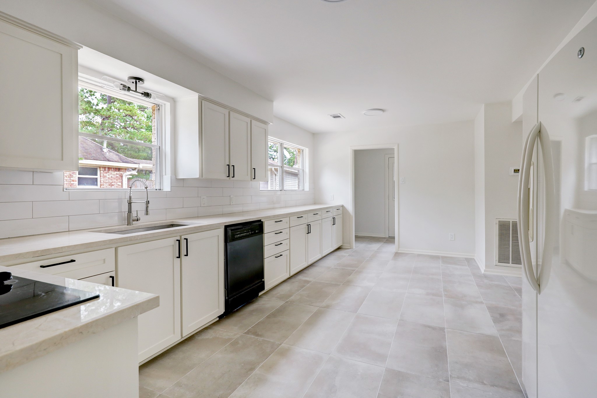 1810 Nocturne Lane Houston, TX 77043 - Photo 13 of 32 a large white kitchen with a sink large window and cabinets