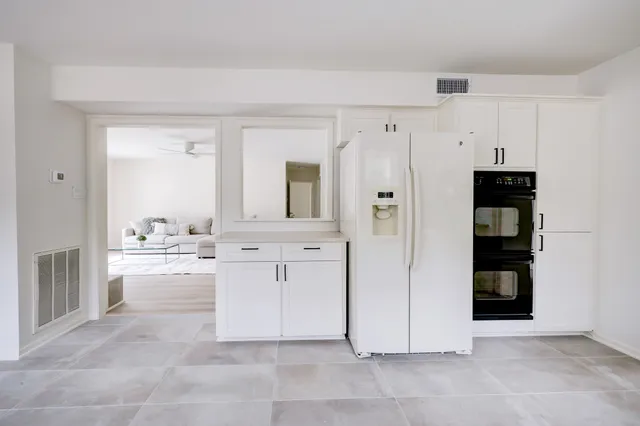 a large white kitchen with cabinets and stainless steel appliances