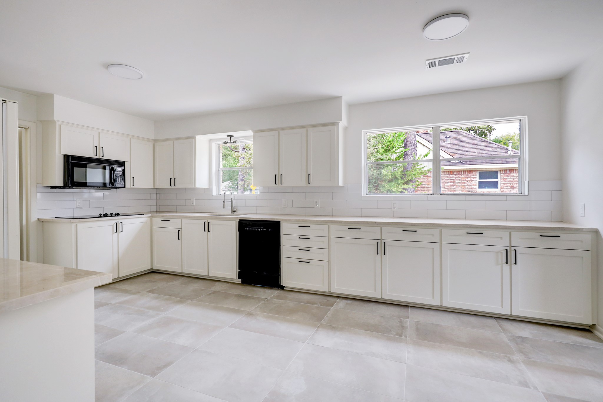 1810 Nocturne Lane Houston, TX 77043 - Photo 15 of 32 a large white kitchen with a stove a sink dishwasher and a window
