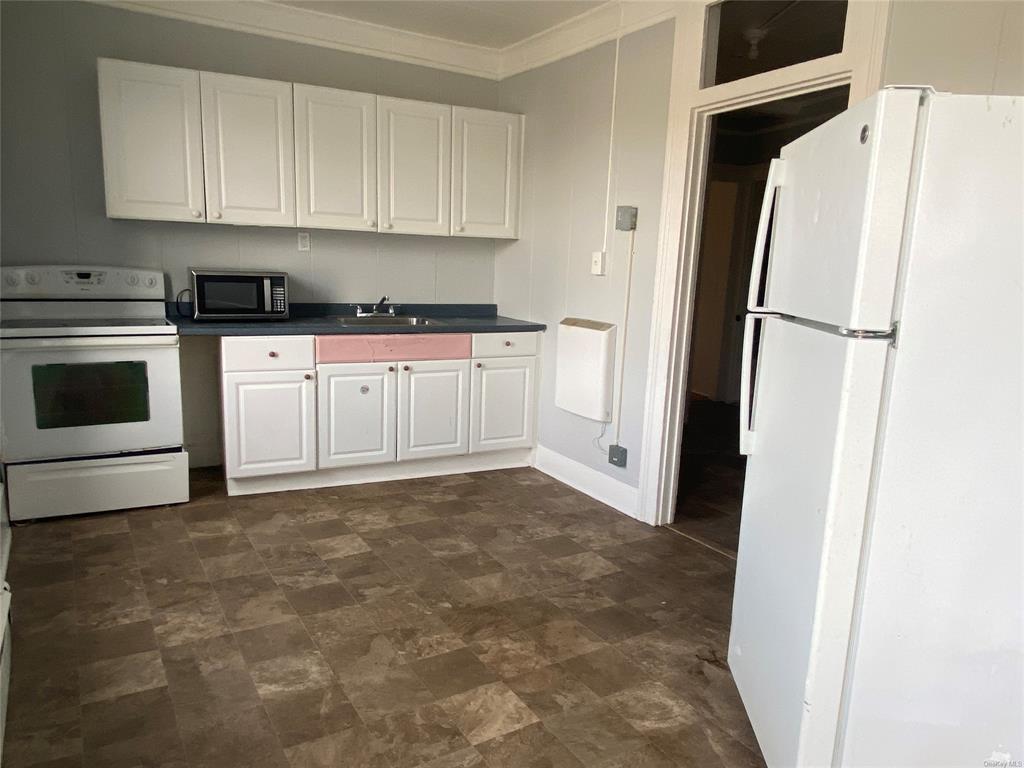 35 Main Street Walden, NY 12586 - Photo 4 of 10 Kitchen featuring white cabinets, white appliances, sink, and ornamental molding