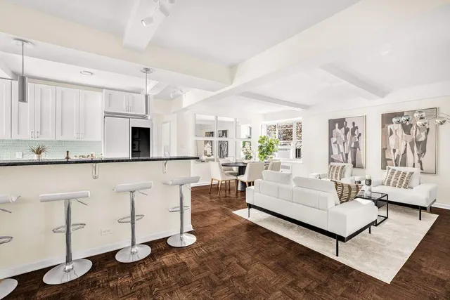 a living room with furniture and kitchen view