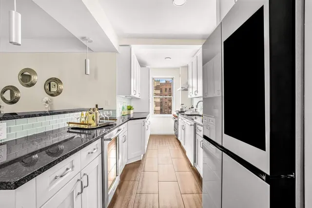 a kitchen with granite countertop stove top oven and cabinets