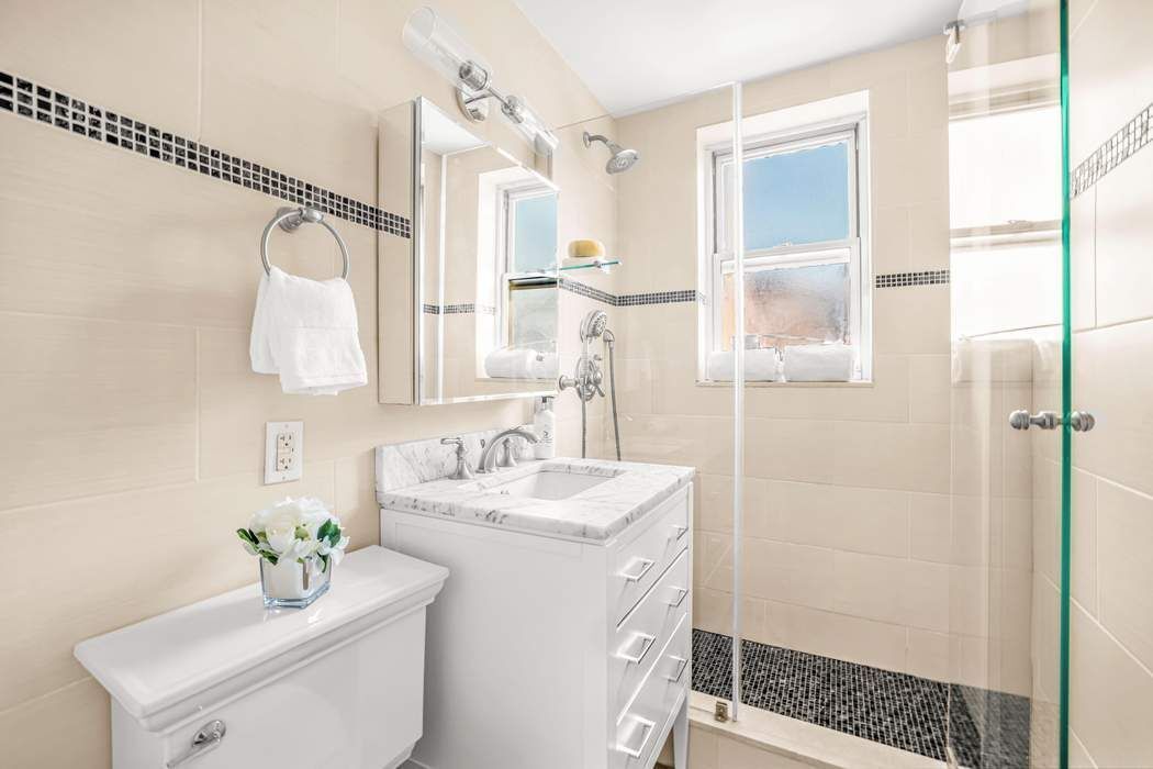 500 Grand Street, Unit C4H Manhattan, NY 10002 - Photo 7 of 11 a bathroom with a sink a toilet and shower