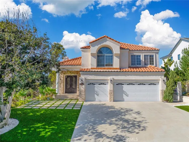 a front view of a house with a garden and yard