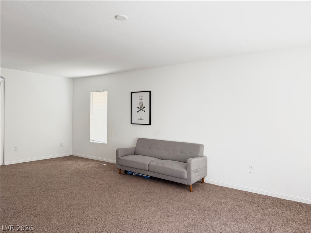 7777 South Westwind Road Las Vegas, NV 89139 - Photo 9 of 46 A well-lit living area features neutral carpeting and a single window.