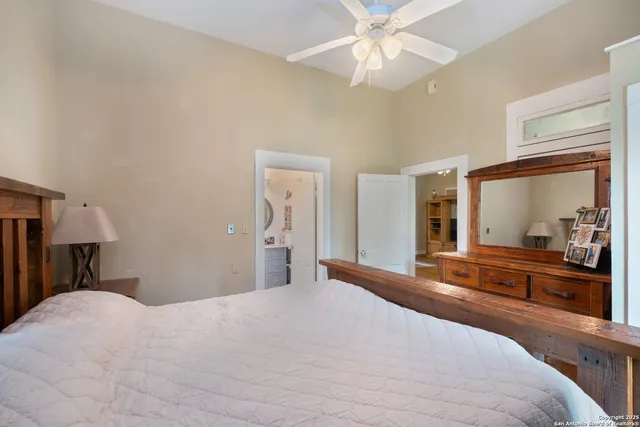 a bedroom with a bed and a chandelier with a flat tv screen