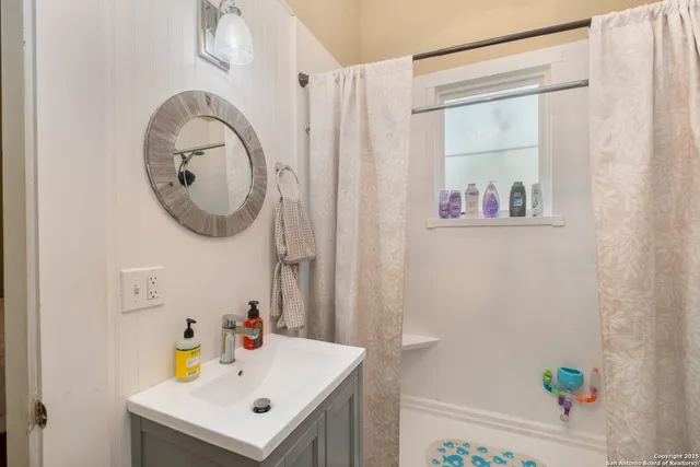 a bathroom with a sink a mirror and a shower curtain