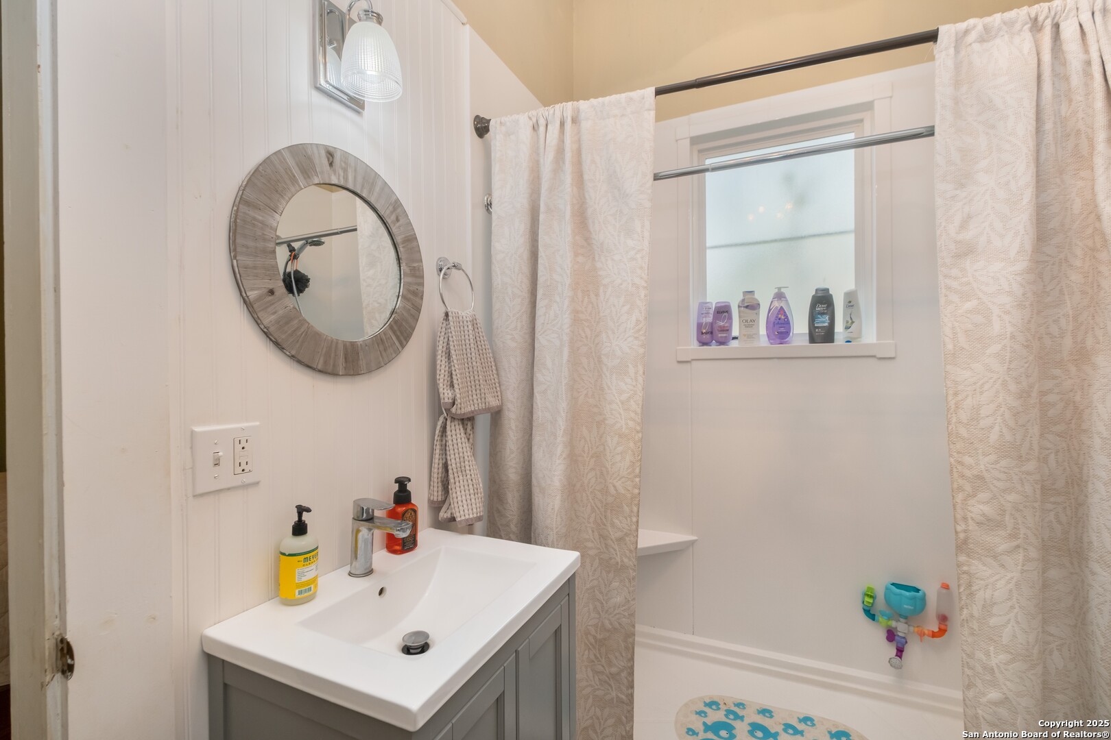 301 Jefferson Drive Devine, TX 78016 - Photo 13 of 29 a bathroom with a sink a mirror and a shower curtain