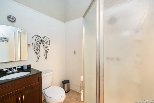 a bathroom with a granite countertop sink a toilet and a mirror