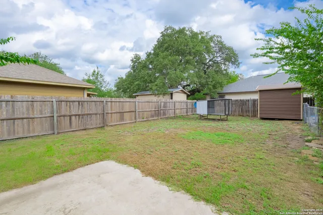 a view of a backyard with a garden and wooden fence