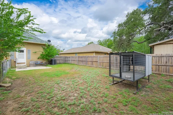 a view of backyard with wooden fence