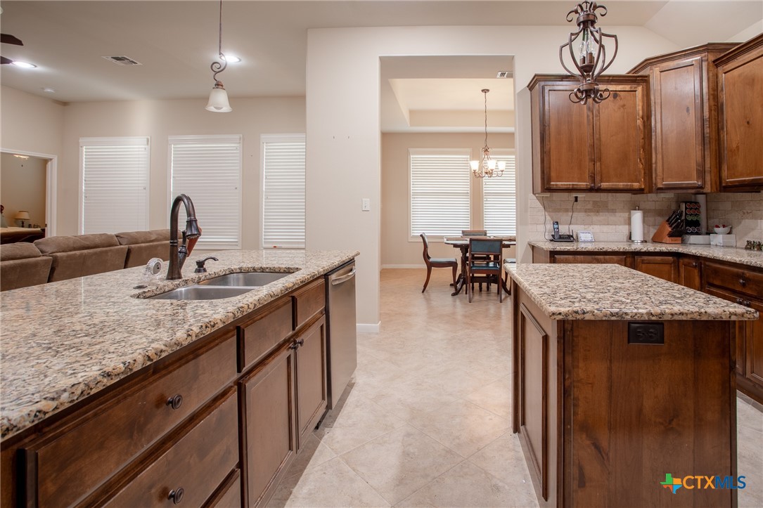 102 Luke Court Victoria, TX 77904 - Photo 11 of 33 a kitchen with center island table and chairs in it