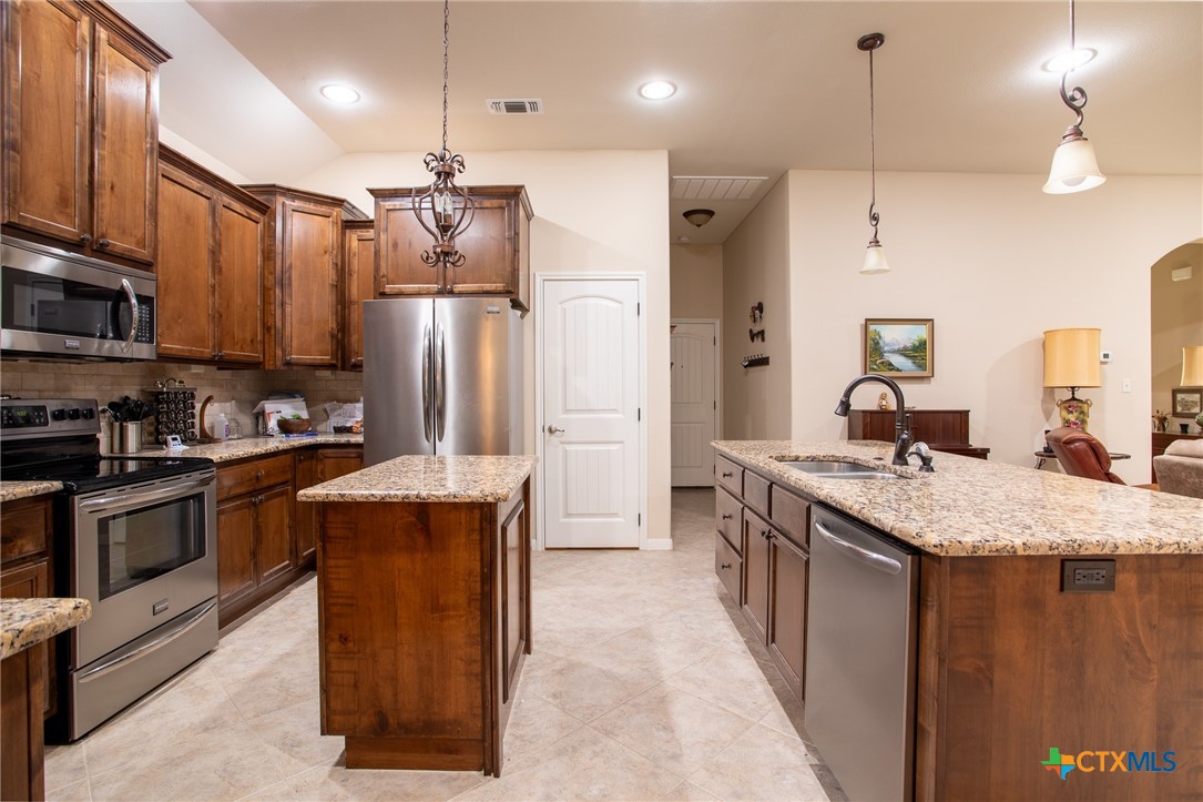 102 Luke Court Victoria, TX 77904 - Photo 12 of 33 a kitchen with stainless steel appliances granite countertop a sink stove and refrigerator
