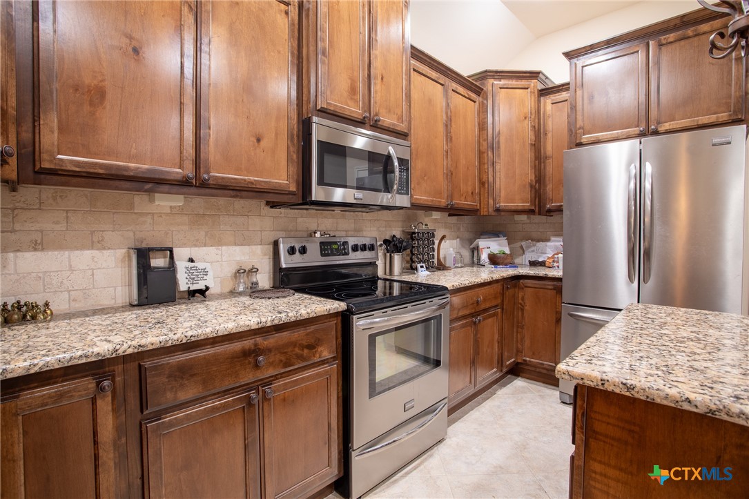 102 Luke Court Victoria, TX 77904 - Photo 14 of 33 a kitchen with stainless steel appliances granite countertop a sink stove and refrigerator