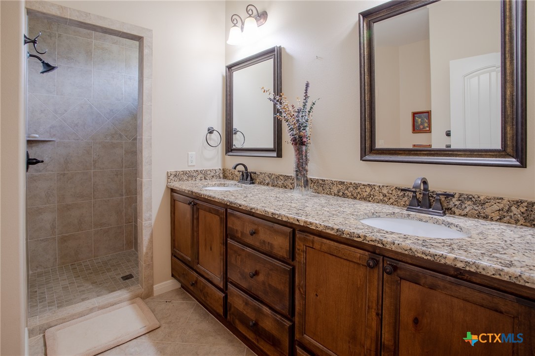 102 Luke Court Victoria, TX 77904 - Photo 20 of 33 a bathroom with a granite countertop sink and a mirror