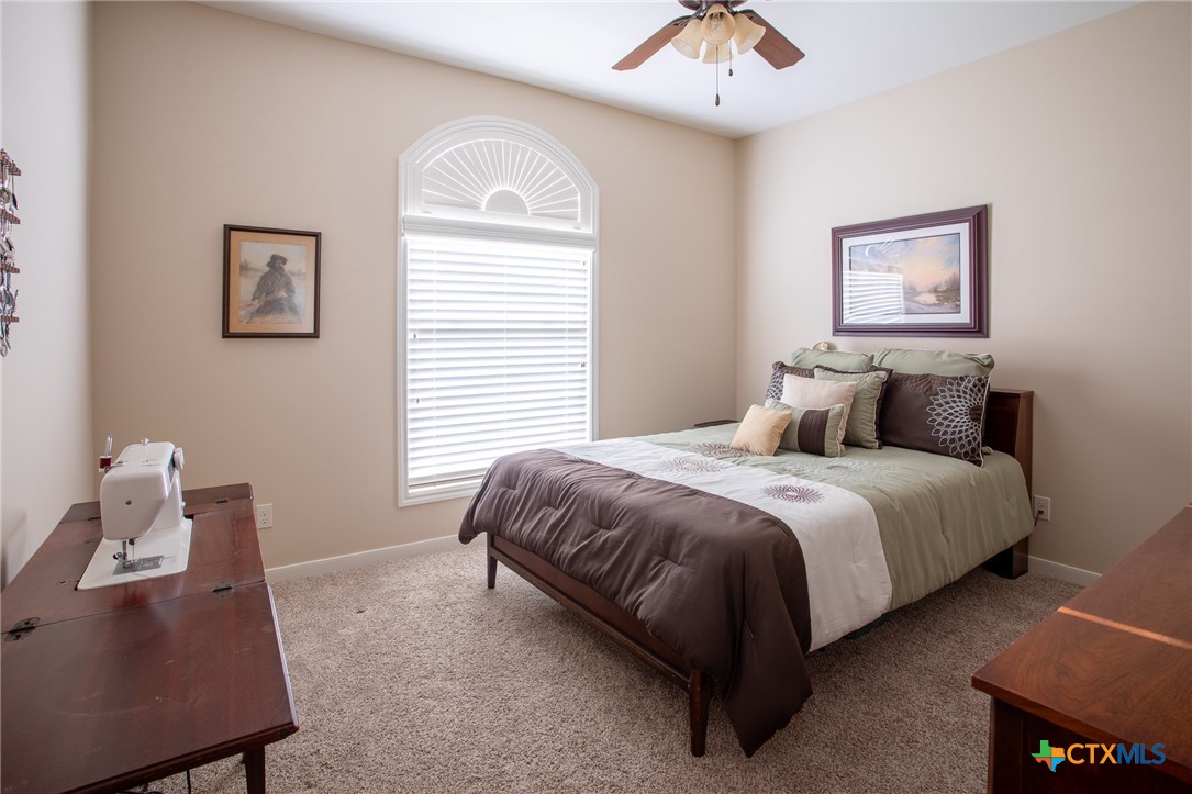102 Luke Court Victoria, TX 77904 - Photo 22 of 33 a bedroom with a bed and a chandelier