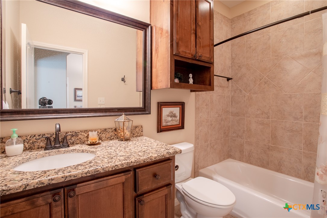 102 Luke Court Victoria, TX 77904 - Photo 24 of 33 a bathroom with a granite countertop sink toilet mirror and bathtub