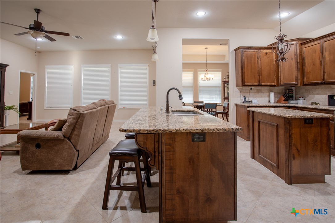 102 Luke Court Victoria, TX 77904 - Photo 10 of 33 a kitchen with kitchen island granite countertop a stove and a sink