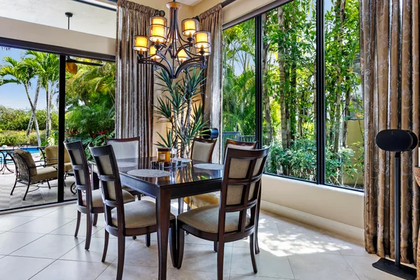 a view of a patio with a table chairs and a small yard