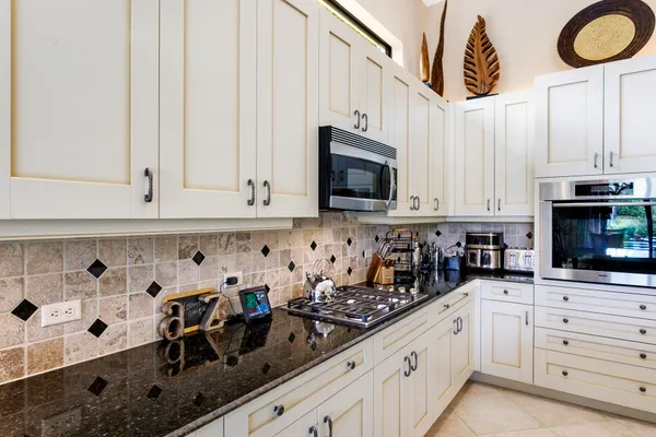 a kitchen with white cabinets and sink