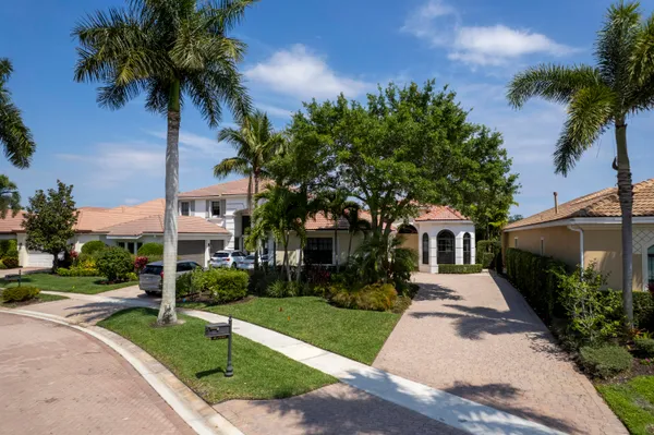 a front view of a house with a yard and potted plants