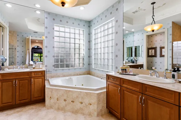 a bathroom with a tub sink and mirror