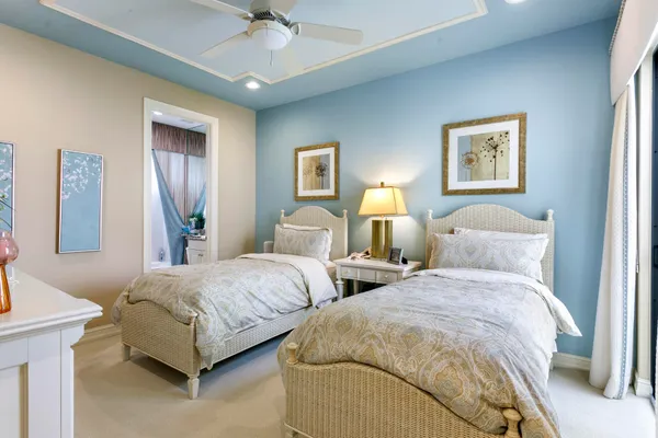a bedroom with two beds and a chandelier