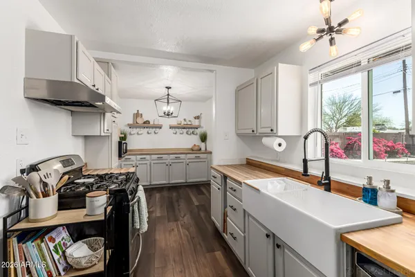 a kitchen that has a lot of cabinets in it and wooden floors