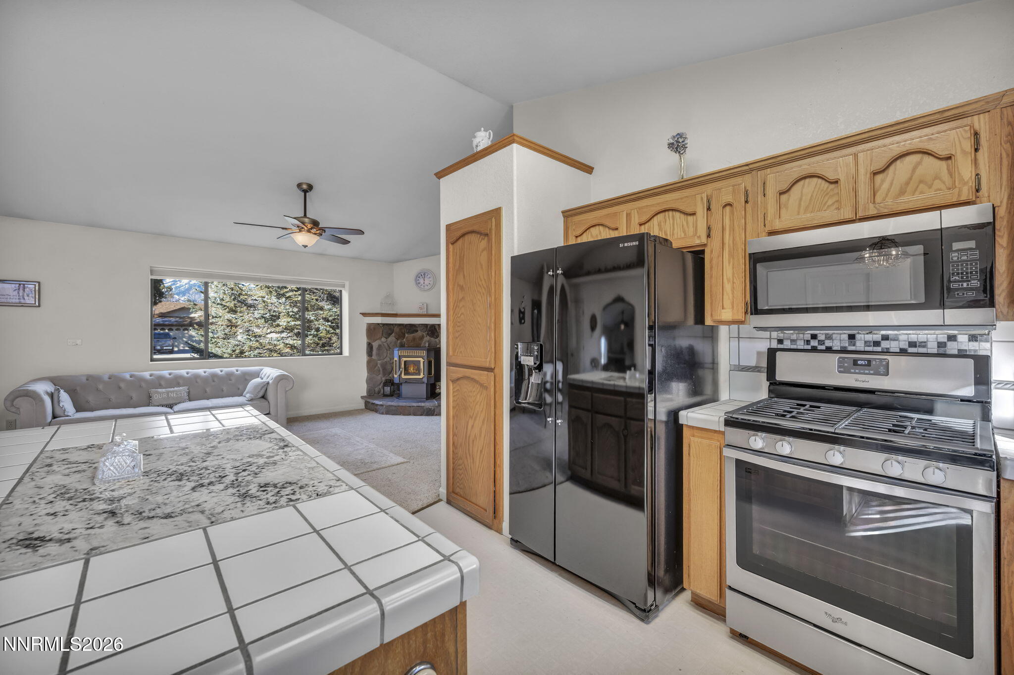 1317 Bridle Way Minden, NV 89423 - Photo 27 of 57 a kitchen with stainless steel appliances kitchen island granite countertop a stove a refrigerator and cabinets