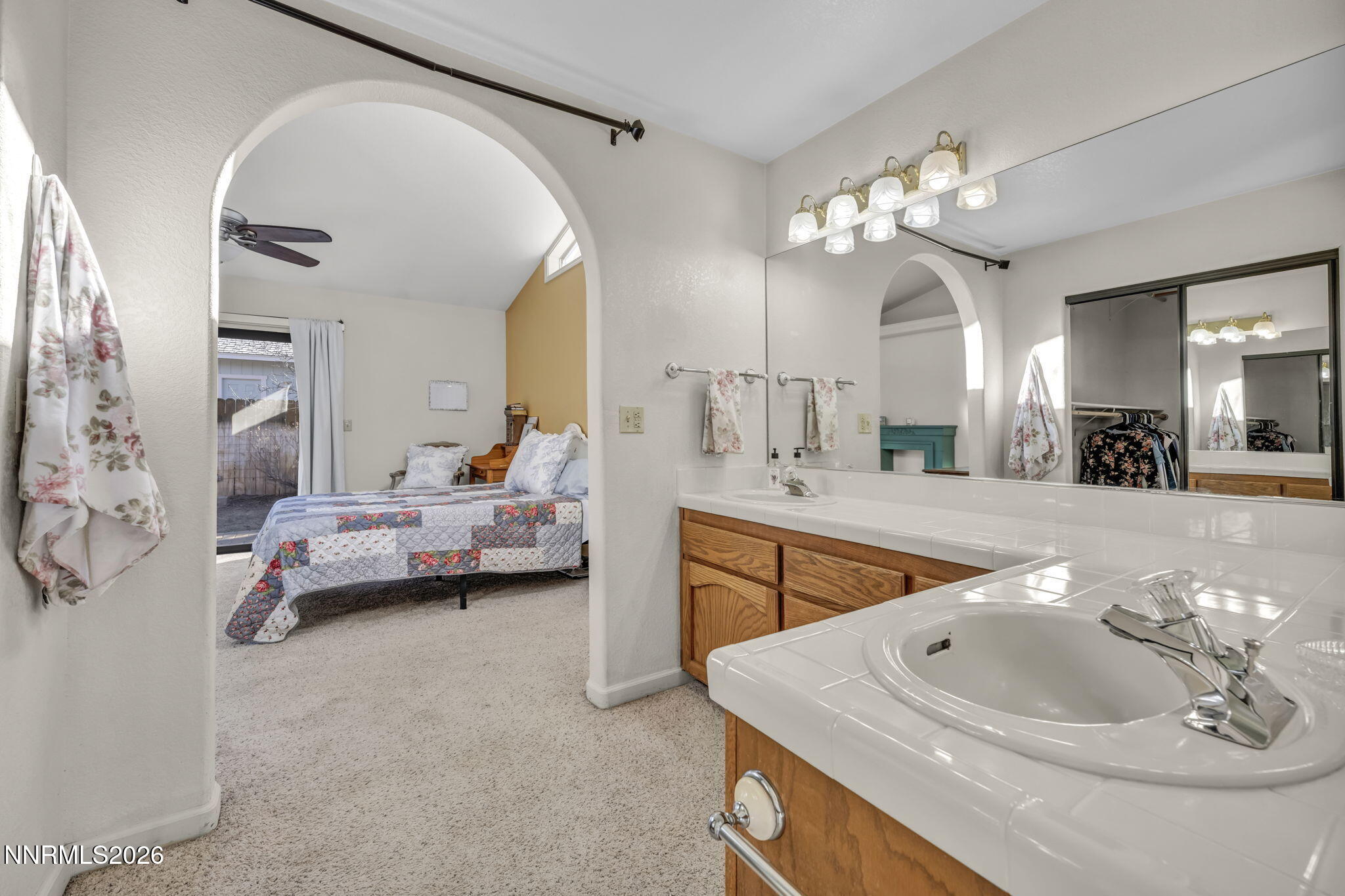 1317 Bridle Way Minden, NV 89423 - Photo 40 of 57 a spacious bedroom with a bed a chandelier and a mirror