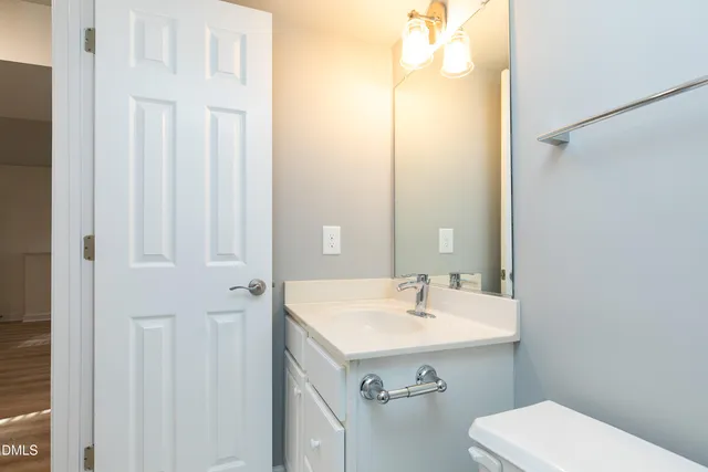 a bathroom with a sink a toilet and mirror