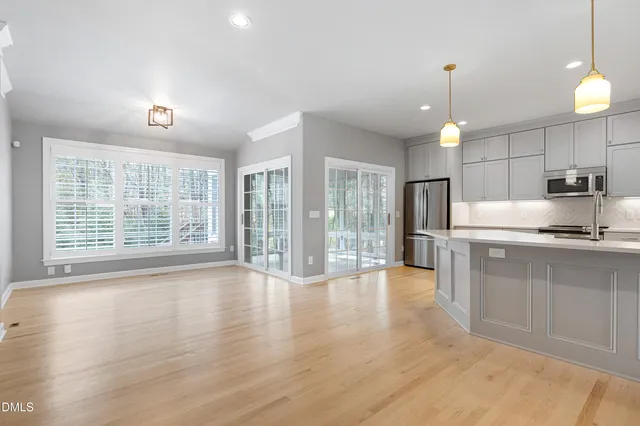 a view of kitchen with granite countertop a stove top oven a sink and a wooden floors