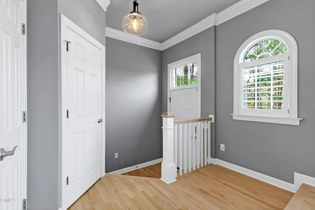 a view of empty room with wooden floor and window