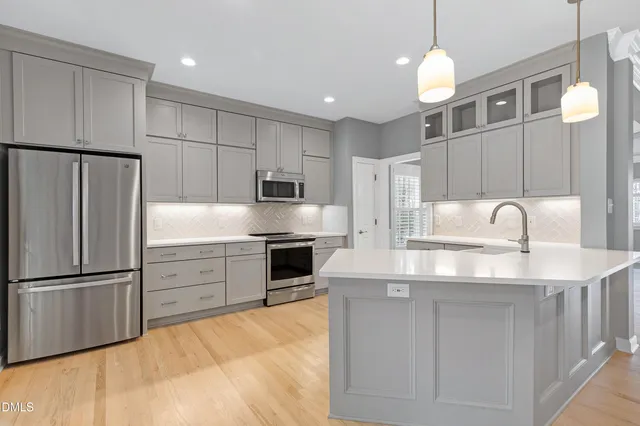 a kitchen with stainless steel appliances granite countertop a sink refrigerator and cabinets